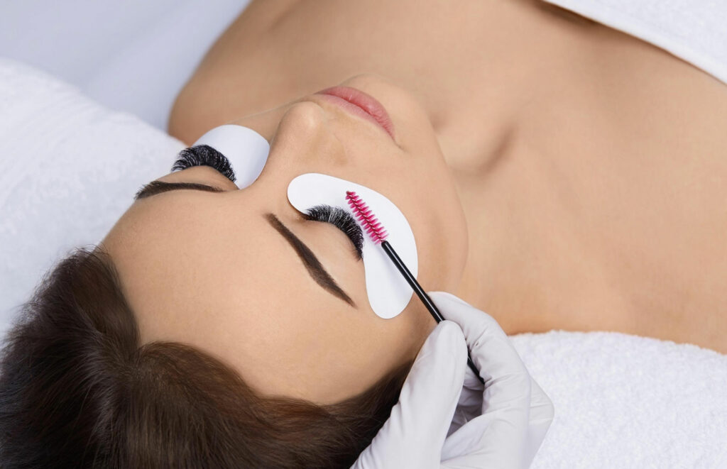 Lash tech lifting woman's eyelashes