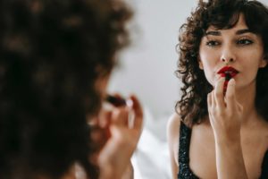 Woman applying bright red lipstick