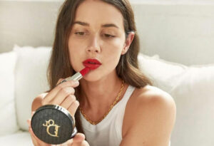 Beauty influencer Sara Crampton putting on lipstick