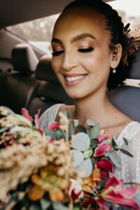 Woman wearing makeup in a car with a bouquet