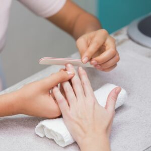 Nail tech filing a woman's nails