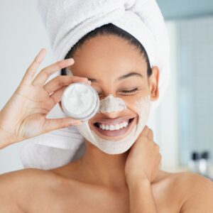 A woman holding the face scrub she put on her face