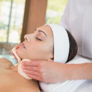 A beauty therapist using pads as part of a facial