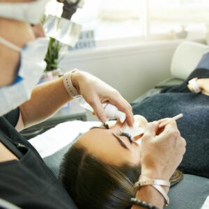 Lash tech adding lash extensions to a woman