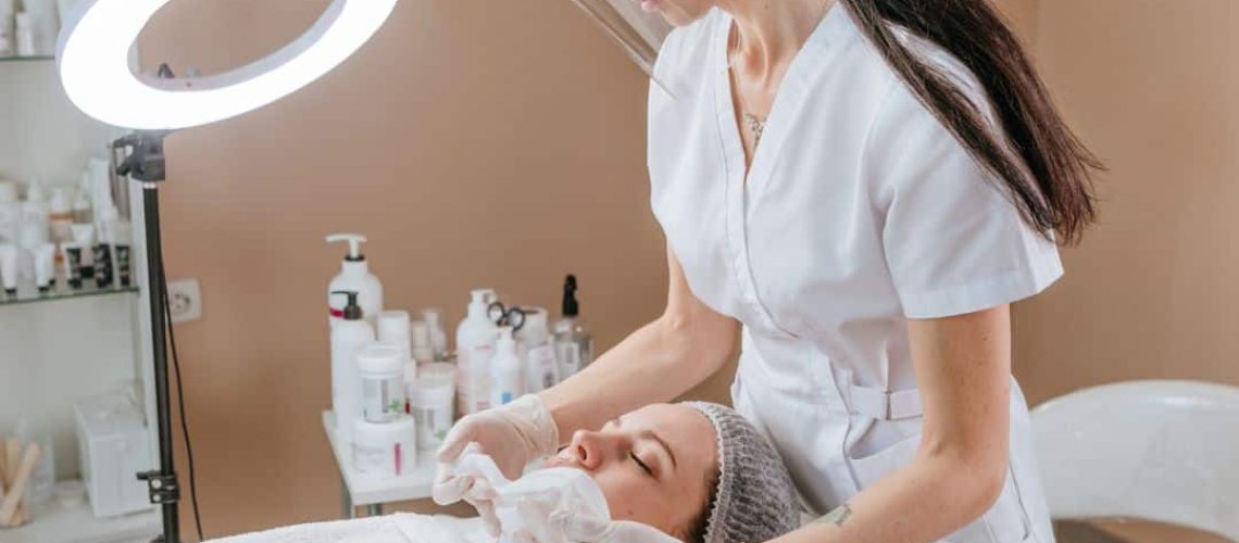 Woman giving another woman a facial treatment