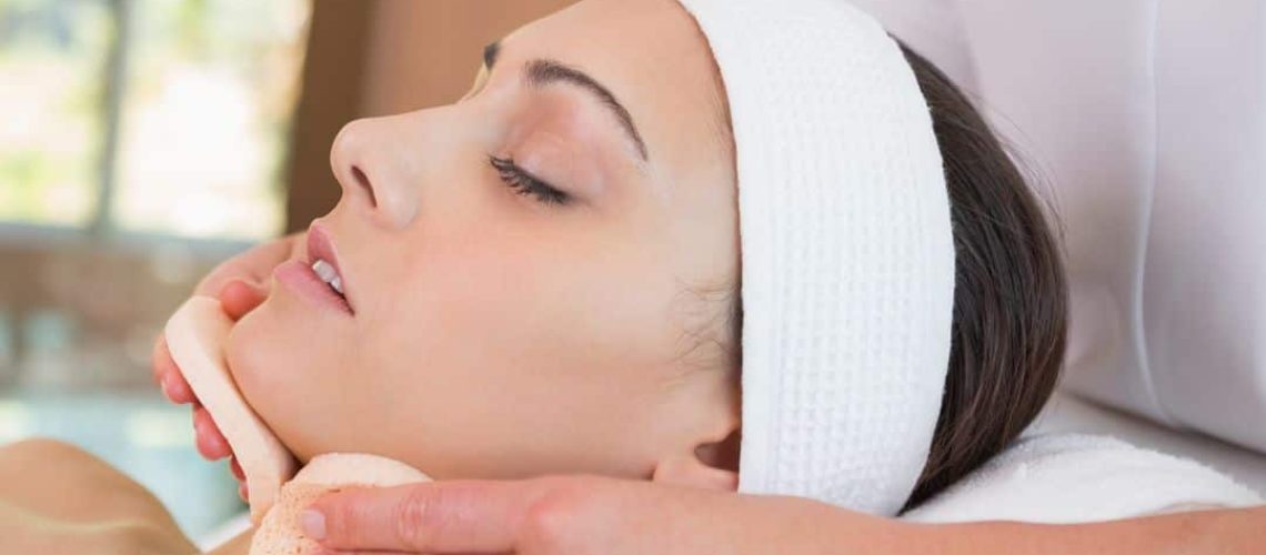 A beauty therapist using pads as part of a facial