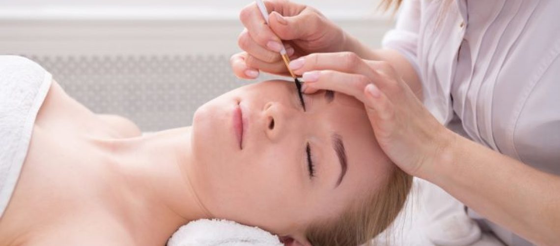 beauty specialist adjusting client's eyelashes