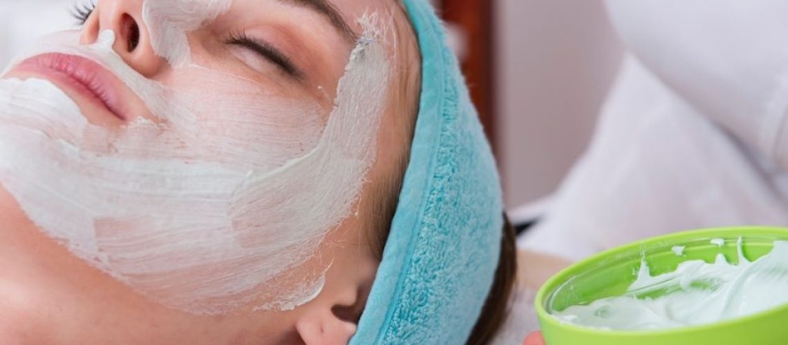 person applying facial mask to customer