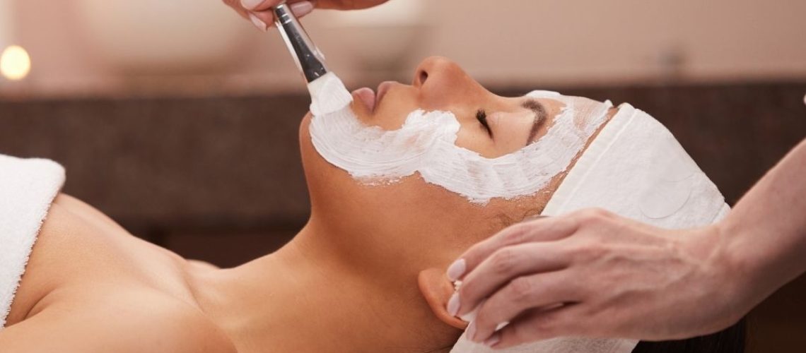 Facialist applying a face mask to a client