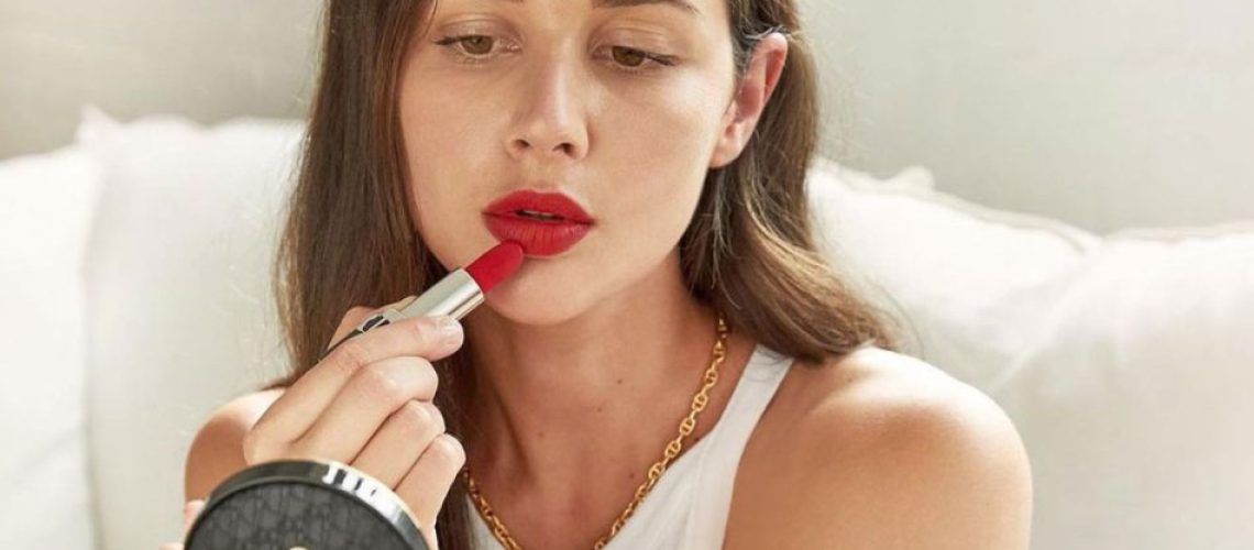 Beauty influencer Sara Crampton putting on lipstick