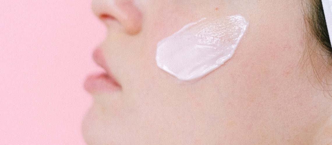 girl with face cream on her left cheek