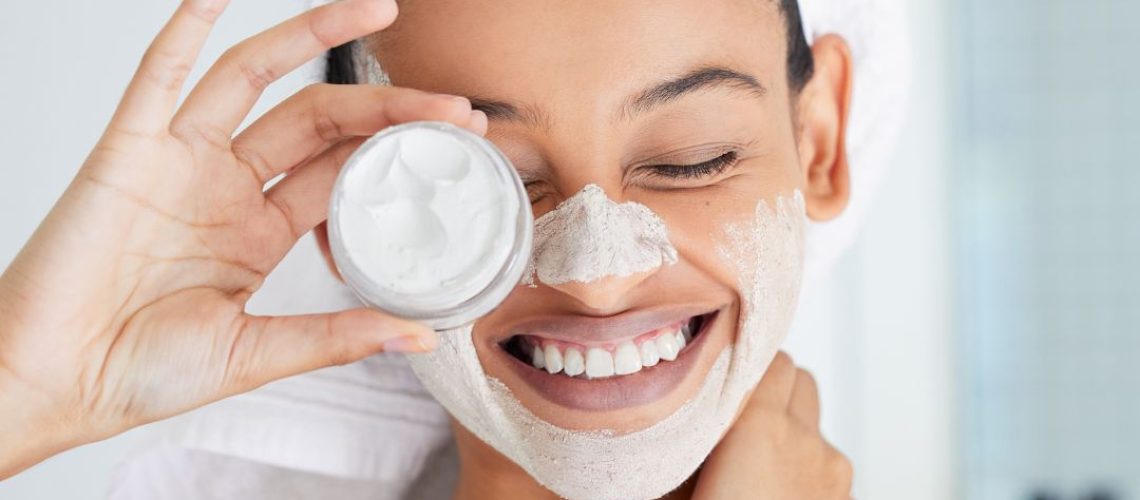 A woman holding the face scrub she put on her face