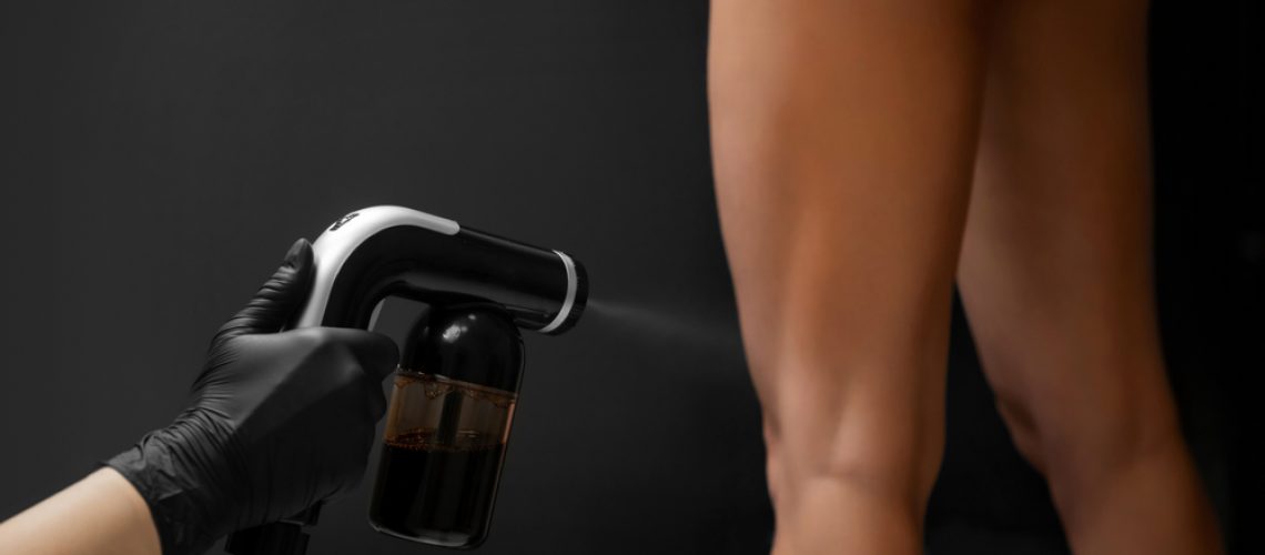 Cosmetology,Professional,Applying,Liquid,Tan,Spray,On,Woman,Skin,With